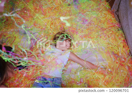 Cheerful teen girl with blonde short hair at a party with colorful confetti 120096701