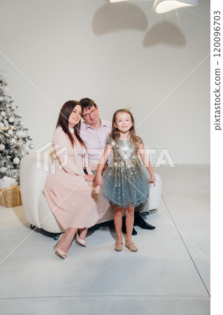 Mom and dad admiring their daughter in a beautiful shiny dress. 120096703