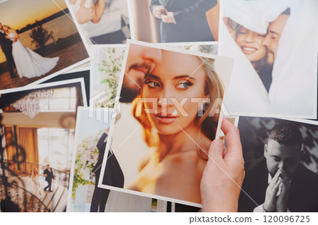 women's hands put on the table and show wedding photos. women's hands put on the table and show wedding photos. 120096725