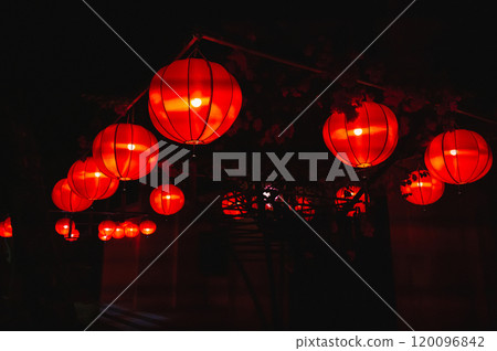 Glowing red traditional paper Chinese lanterns decorate the facade of building in Asia at night Glowing red traditional paper Chinese lanterns decorate the facade of building in Asia at night 120096842