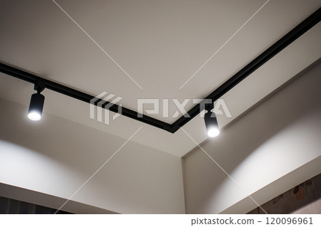 black ceiling lights on a white ceiling. Modern lighting. black ceiling lights on a white ceiling. Modern lighting. 120096961