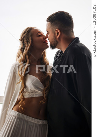 A gentle and romantic man and woman in silk pajamas on the windowsill 120097108