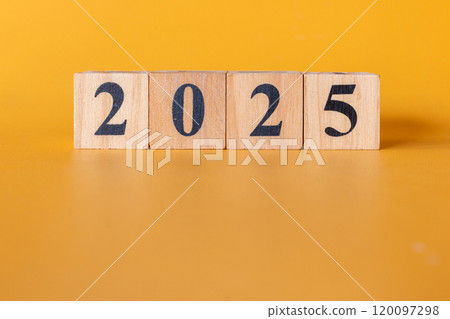 Wooden blocks with black numbers arranged to show 2025 against a bright yellow backdrop. Wooden blocks with black numbers arranged to show 2025 against a bright yellow backdrop. 120097298