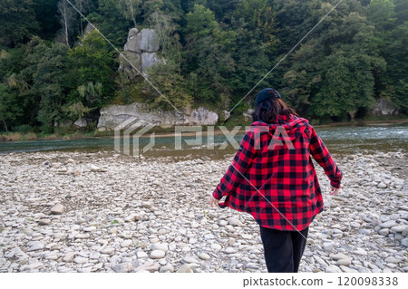 Woman smiling and walking on a rocky riverbank Woman smiling and walking on a rocky riverbank 120098338