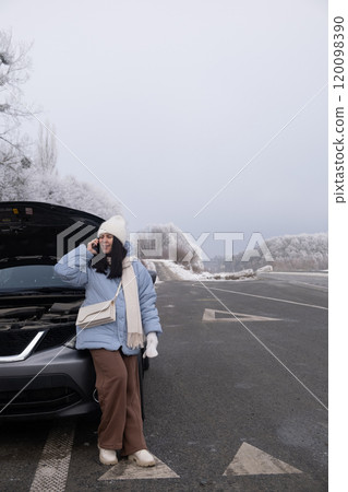 Woman watching at Car Engine on Snowy Roadside 120098390
