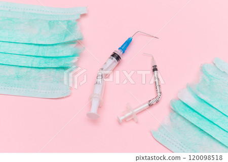 Broken Medical Syringe and Torn Medical Face Mask on the Pink Background Broken Medical Syringe and Torn Medical Face Mask on the Pink Background 120098518