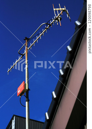 Television antenna on a private house and blue sky 120098798