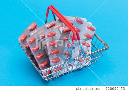 Pills and Capsules in Shopping Basket on Blue Background 120099453