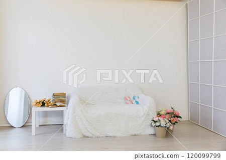 White sofa with flowers and gifts for the holiday in the interior of the white room 120099799