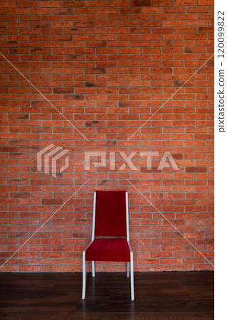 Red vintage chair in interior near empty brick wall 120099822