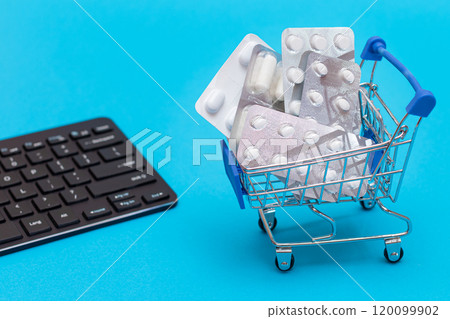 Ordering Medicines. Pills and Capsules in a Shopping Cart on Blue Background 120099902