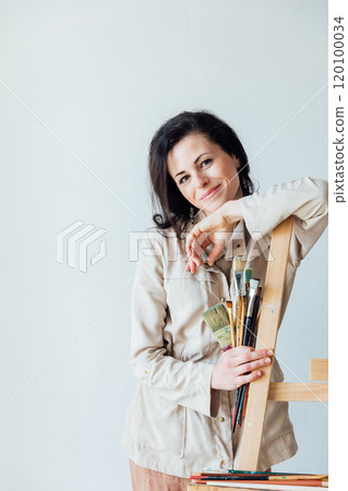 Female artist holding paint brushes in her hands 120100034