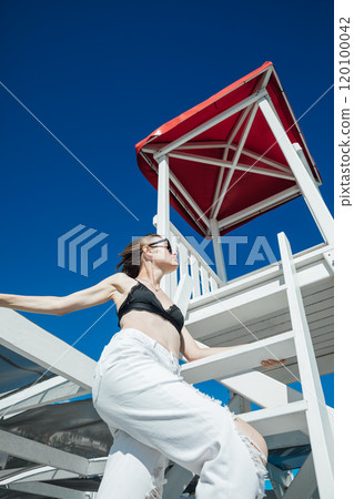 Beautiful woman in swimsuit sunbathing on the beach by the sea Beautiful woman in swimsuit sunbathing on the beach by the sea 120100042