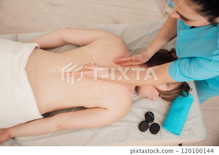 chiropractor giving medical facial massage to woman in spa 120100144