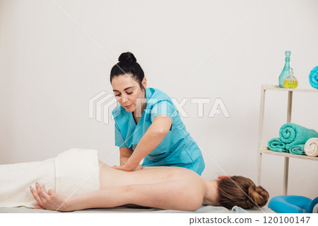 A woman is given a medical massage by a chiropractor 120100147
