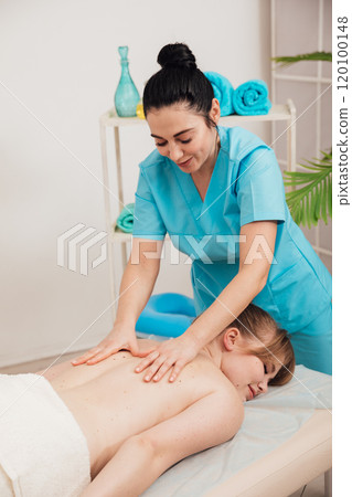 A woman is given a medical massage by a chiropractor A woman is given a medical massage by a chiropractor 120100148