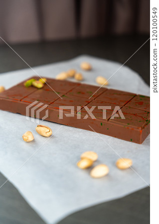 Bar of trend Dubai chocolate with pistachio paste and kataifi dough. Confectionery handmade sweets at home in the kitchen. Bar of trend Dubai chocolate with pistachio paste and kataifi dough. Confectionery handmade sweets at home in the kitchen. 120100549