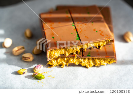 Trend Dubai chocolate with pistachio paste and kataifi dough at sun lights. Confectionery handmade sweets at home in the kitchen.  120100558