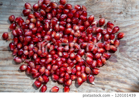 pomegranate seeds background on a wooden background, top view pomegranate seeds background on a wooden background, top view 120101439