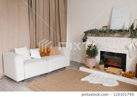 Living room with a white couch and a fireplace. Cozy apartment and warm atmosphere for Christmas 120101799
