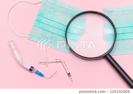 Broken Medical Syringe and Green Torn Medical Face Mask with Magnifying Glass 120102008