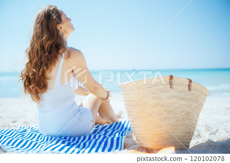 relaxed modern woman on seacoast with straw bag 120102078