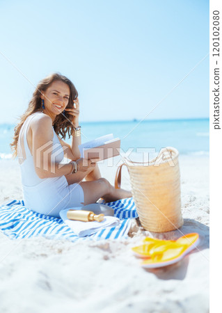 happy modern woman on seacoast with straw bag and book happy modern woman on seacoast with straw bag and book 120102080