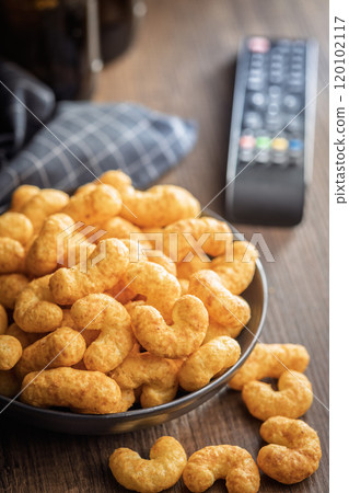 Puffed crispy Peanut flips on plate on wooden table. 120102117