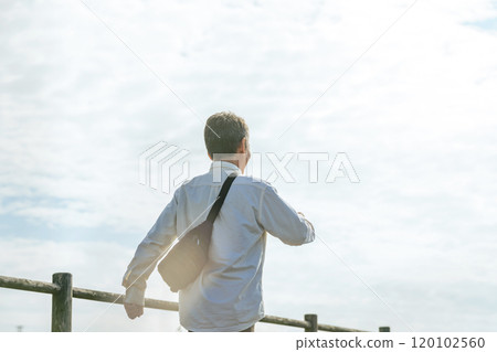 Back view of a senior man walking on a promenade Back view of a senior man walking on a promenade 120102560