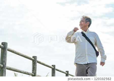 Senior man walking energetically along the promenade Senior man walking energetically along the promenade 120102562