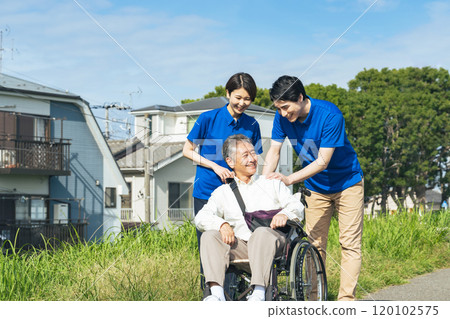 護理人員與坐在輪椅上的老人交談 120102575