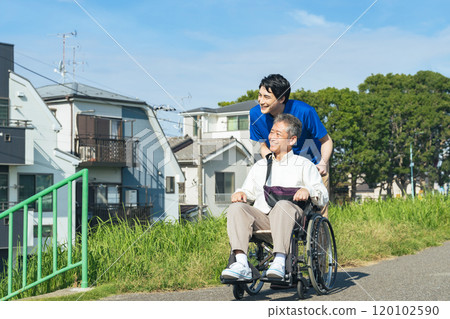 一名坐在輪椅上的老人和一名在鎮上行走的護理人員 一名坐在輪椅上的老人和一名在鎮上行走的護理人員 120102590
