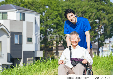 一名坐在輪椅上的老人和一名在鎮上行走的護理人員 120102598