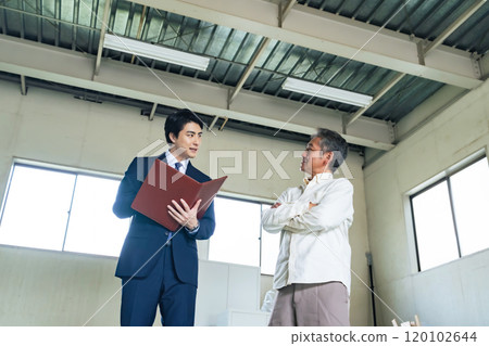 一位老人和一位推銷員正在檢查房產 一位老人和一位推銷員正在檢查房產 120102644