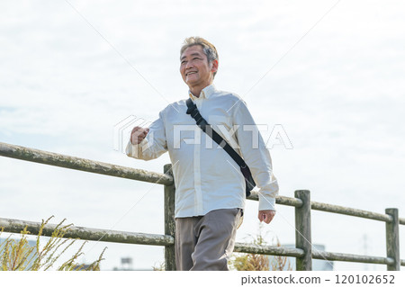 Senior man walking energetically along the promenade 120102652