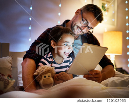She loves story time with daddy. Cropped shot of a father reading his young daughter a bedtime story on a tablet. 120102963