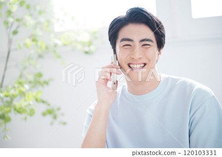 Refreshing image of handsome man talking on the phone looking up at camera, close-up Refreshing image of handsome man talking on the phone looking up at camera, close-up 120103331