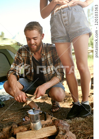 Camp coffee is on the fire. Shot of a young couple of campers preparing a campfire to make coffee. Camp coffee is on the fire. Shot of a young couple of campers preparing a campfire to make coffee. 120103363