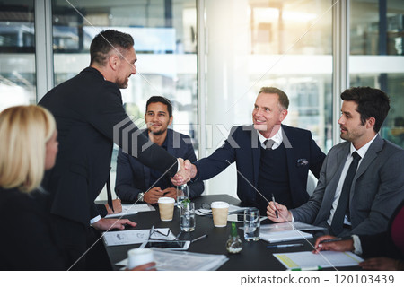 Im glad everyone agrees. Shot of two cheerful businessmen shaking hands in agreement in a boardroom at the office. 120103439