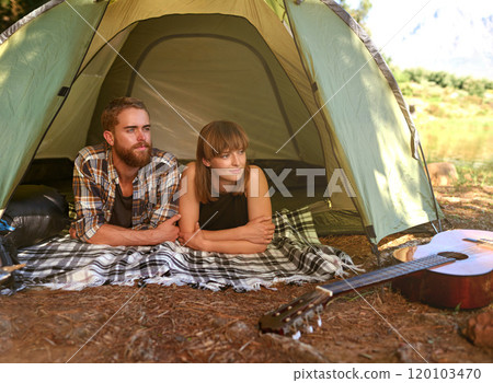 Into the woods. Shot of a young couple lying in a tent looking outwards. 120103470