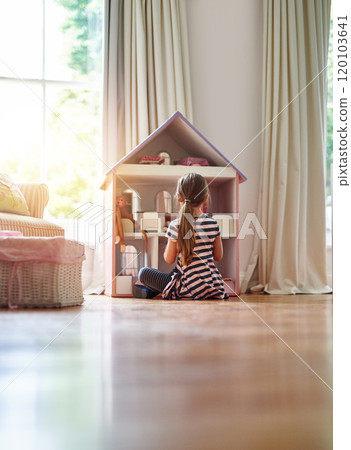 Giving her dolls a place to call home. Shot of a little girl playing with a dollhouse at home. Giving her dolls a place to call home. Shot of a little girl playing with a dollhouse at home. 120103641