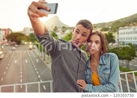 Lets get weird. Shot of a happy young couple taking a selfie together in the city. 120103730