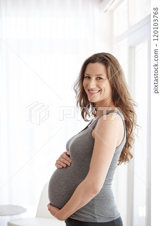 Excited about motherhood. Cropped portrait of a young pregnant woman standing in her home. 120103768