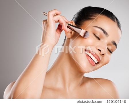 A bit of glamour makes me feel good. Studio shot of an attractive young woman applying makeup against a grey background. 120104148