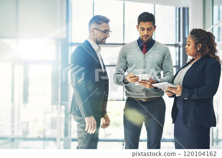 Success is their biggest priority. Shot of a group of coworkers talking together over a digital tablet in an office. Success is their biggest priority. Shot of a group of coworkers talking together over a digital tablet in an office. 120104162