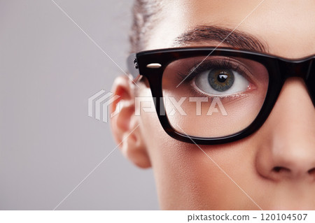 Facial fashion. Closeup studio portrait of a young woman wearing glasses against a gray background. 120104507