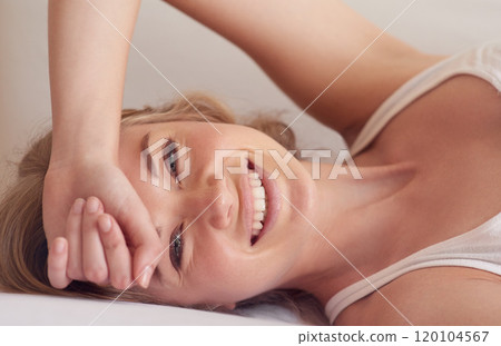 Start your day with a smile. Portrait of a beautiful young woman lying on her bed. Start your day with a smile. Portrait of a beautiful young woman lying on her bed. 120104567