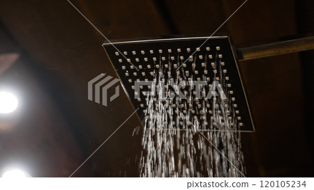 Close-up interior of a stylish shower spraying water. A stylish shower from which water begins to pour, slow motion. 120105234