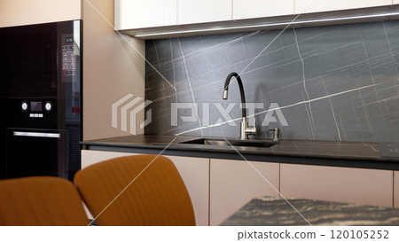 Modern kitchen interior in a furniture showroom. Elegant modern kitchen. Modern kitchen set. Modern kitchen interior in a furniture showroom. Elegant modern kitchen. Modern kitchen set. 120105252