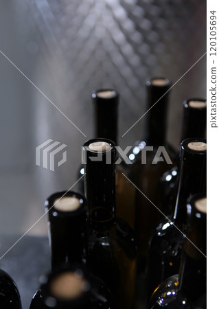 Bottles of wine without labels. Young wine is bottled. Craft winery. Large number of bottles of wine. 120105694